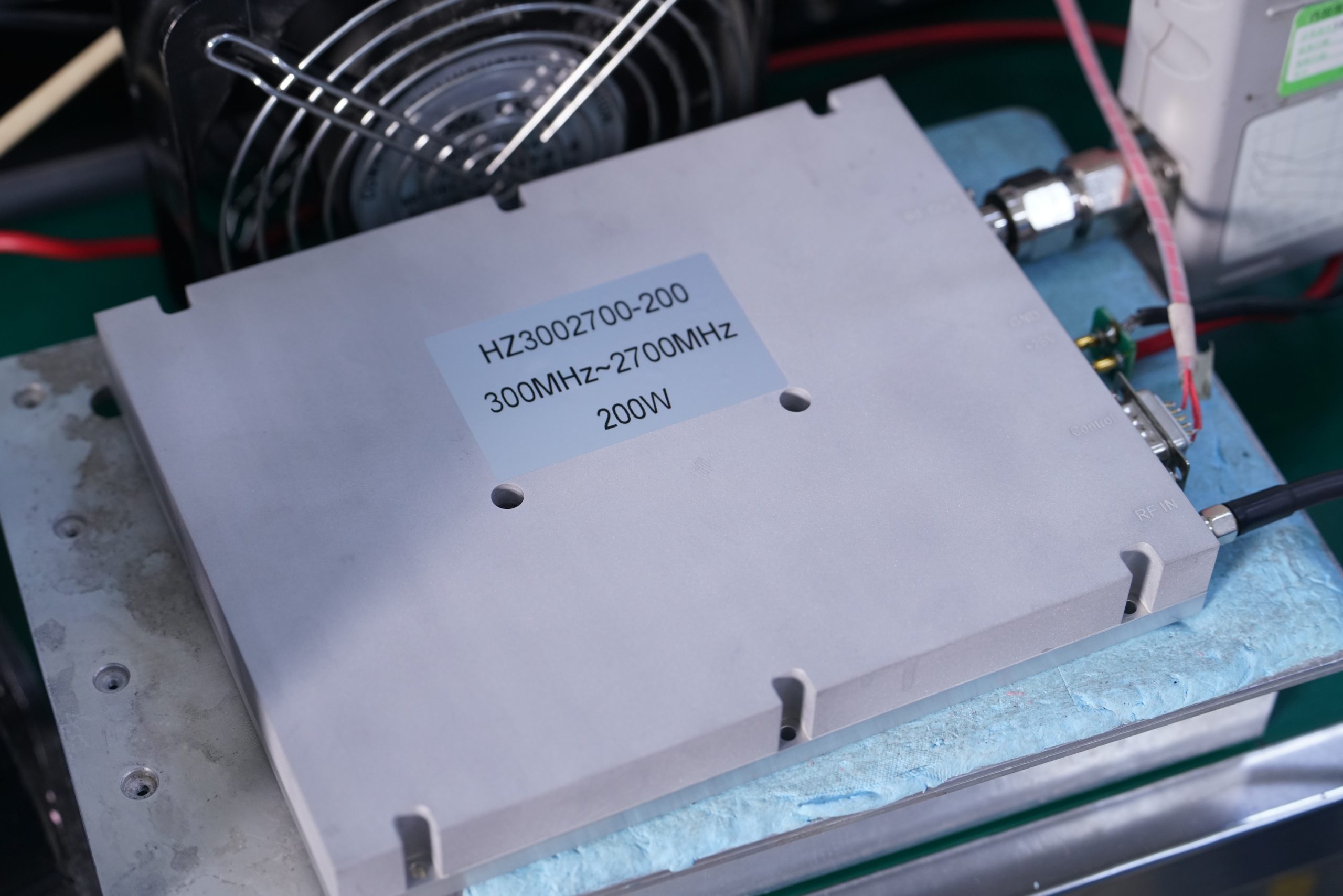 Wideband high-power RF PA undergoing factory output, DC, spectrum, and shipment verification
