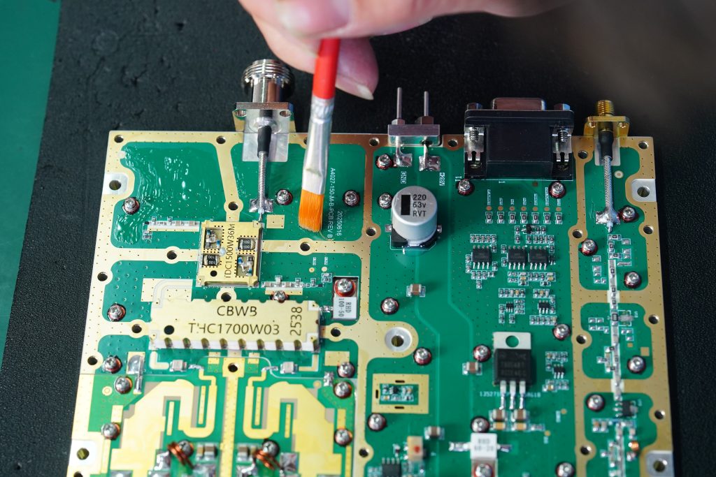 Manual brush application of conformal coating on selected RF PA PCBA areas while controlled interfaces remain clear